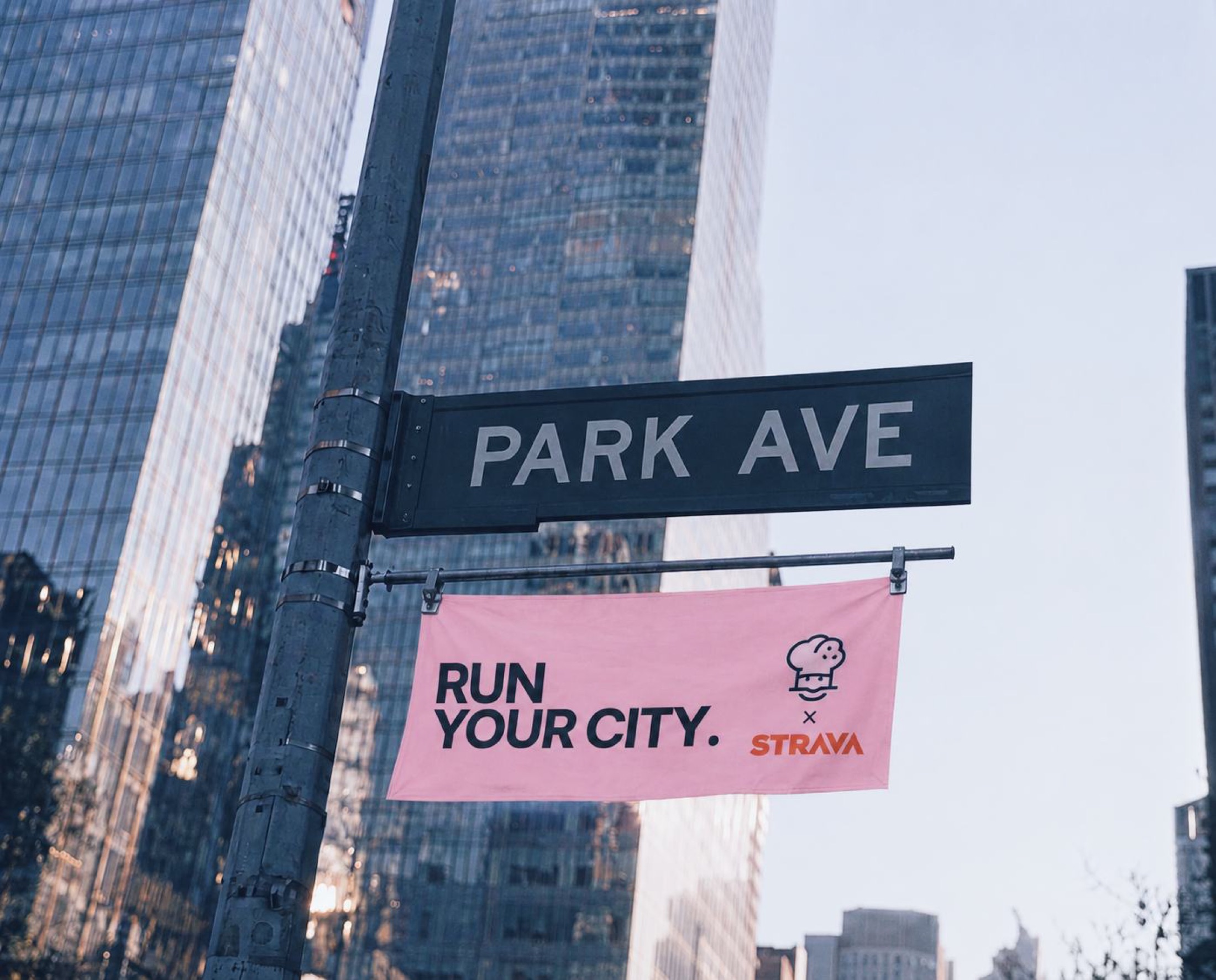 A Run Your City banner hanging under a Park Ave street sign
